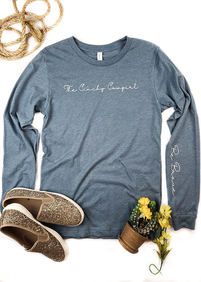 Be Brave Cinchy Cowgirl Heather Slate Long Sleeve Graphic Tee | TCC Graphic Tanks & Tees 4 The Cinchy Cowgirl Heather Slate Be Brave Long Sleeve Graphic Tee