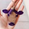 The Cinchy Cowgirl Purple & Champagne Cow Head Keychain